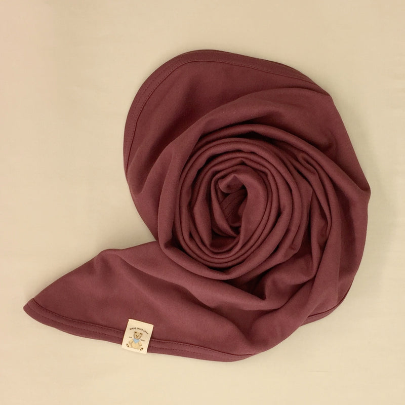 Minimalist cotton baby swaddle blanket in Crushed Berry. Made in Canada
